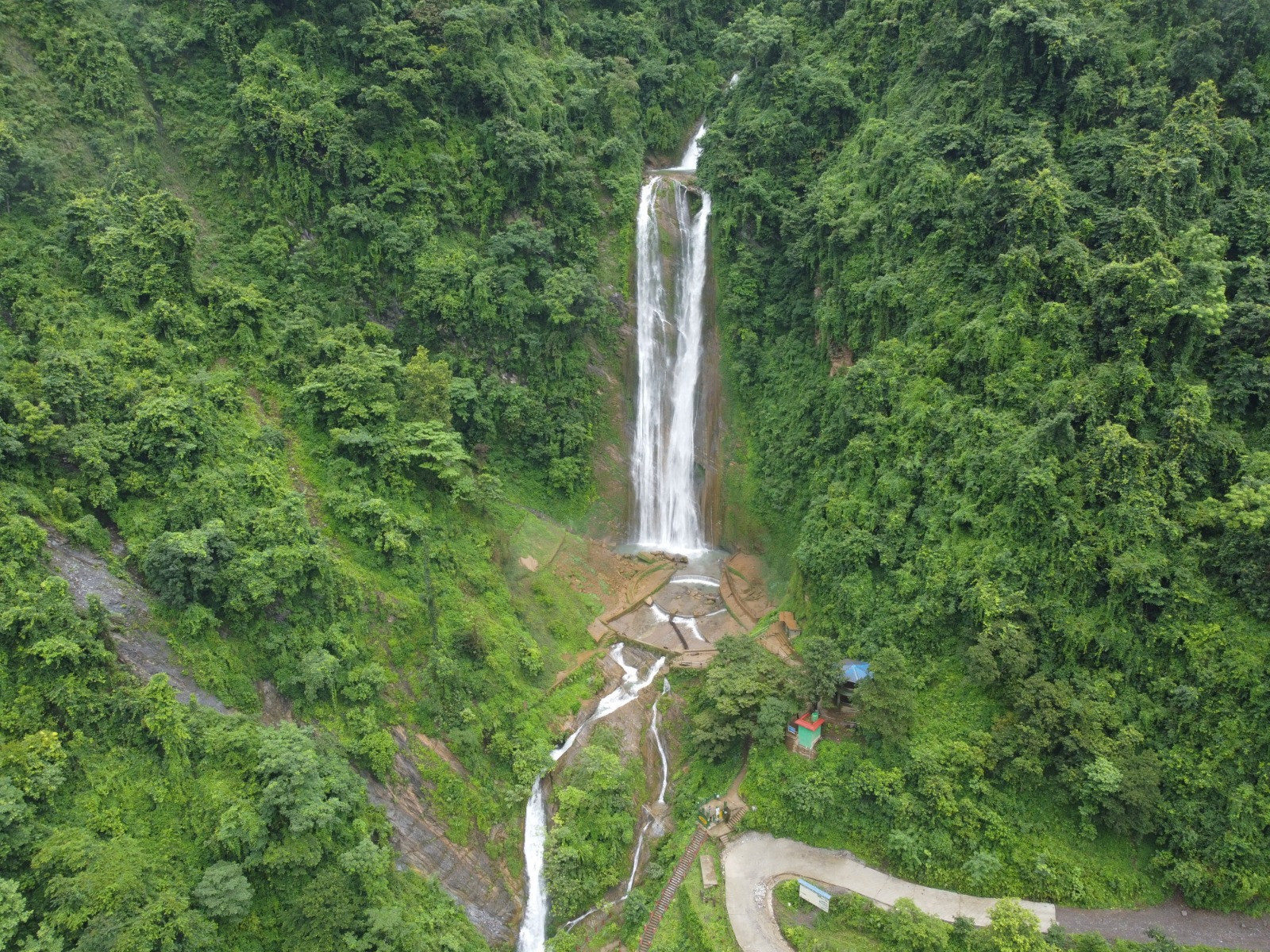 A picturesque view of majestic Jalbire waterfalls surrounded by the lush green Forest.
